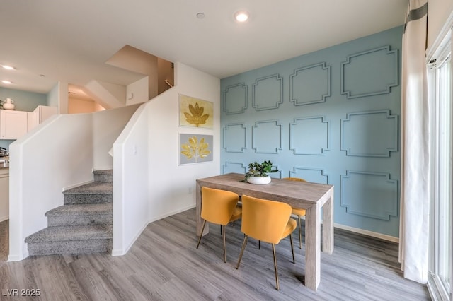 dining area with stairway, light wood-type flooring, and baseboards