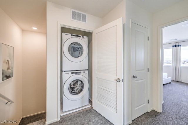 washroom with visible vents, baseboards, carpet, laundry area, and stacked washer / drying machine