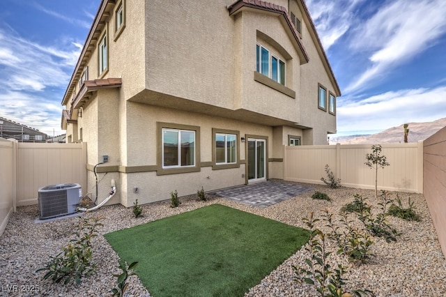 back of house with a patio area, central AC, a fenced backyard, and stucco siding