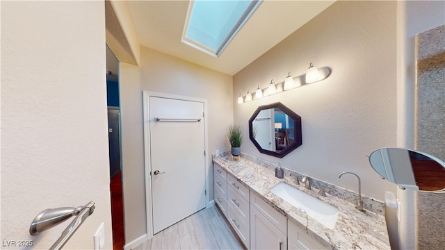 bathroom with vaulted ceiling and vanity