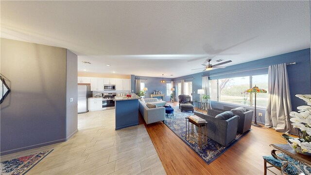 living room with ceiling fan and recessed lighting