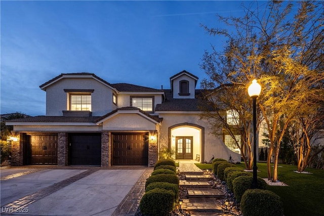 traditional-style home with french doors, stucco siding, an attached garage, driveway, and a front lawn