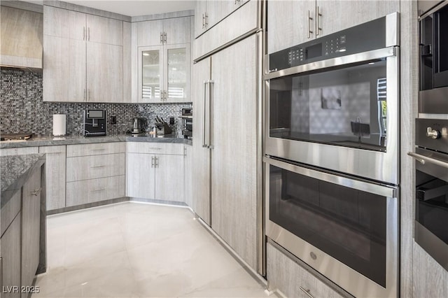 8000 Clock Tower Ct, Las Vegas, NV 89117 - kitchen featuring double oven, backsplash, paneled built in refrigerator, premium range hood, and dark stone counters