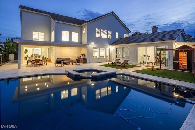 back of property with outdoor lounge area, stucco siding, a patio area, and a pool with connected hot tub