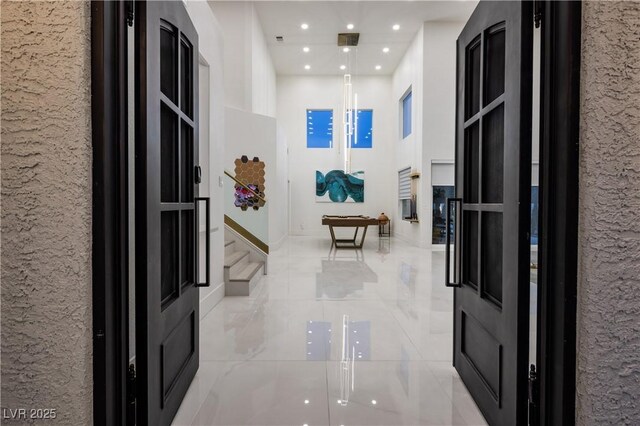 hallway featuring light tile patterned flooring, a textured wall, and recessed lighting