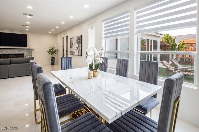 tiled dining room featuring recessed lighting and a fireplace