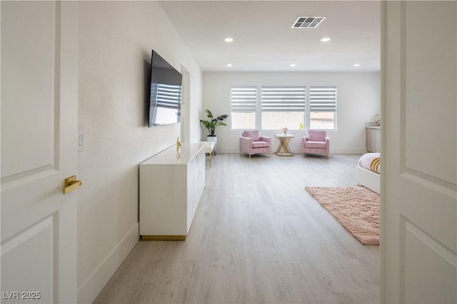 hall featuring light wood-type flooring, baseboards, and recessed lighting