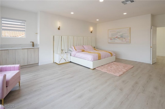 bedroom featuring recessed lighting, light wood-style floors, and baseboards