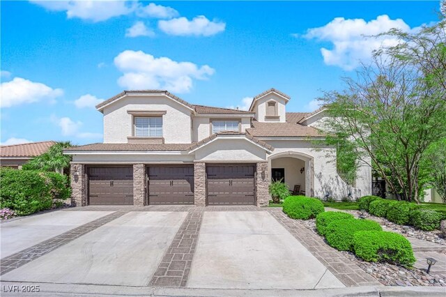 view of front of property with driveway, a garage, stucco siding, stone siding, and a tile roof