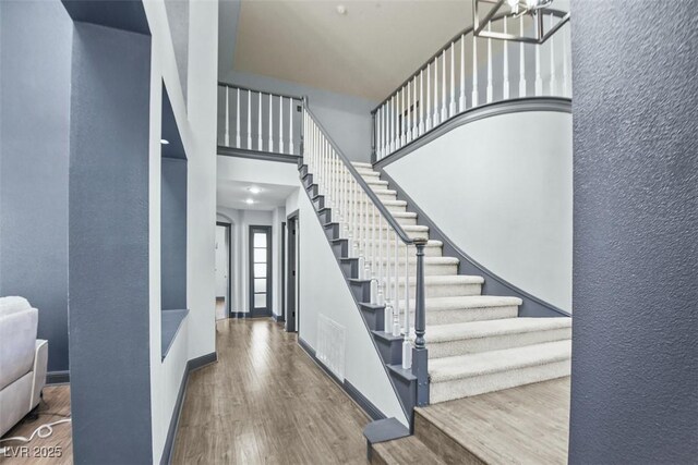 9709 Terrace Green Ave, Las Vegas, NV 89117 - entryway featuring baseboards, wood finished floors, a towering ceiling, and stairs