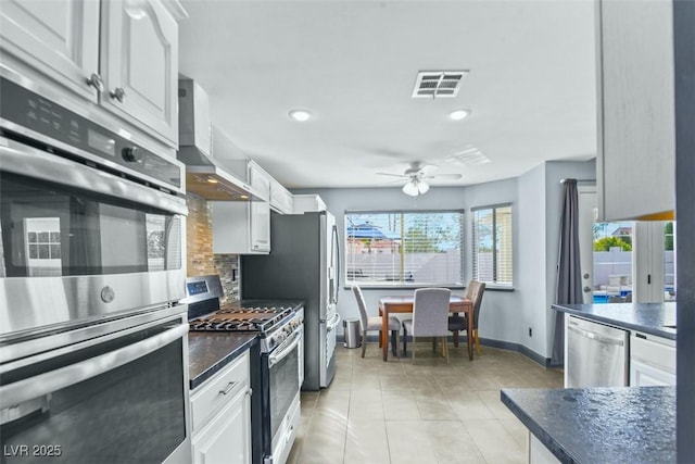 9709 Terrace Green Ave, Las Vegas, NV 89117 - kitchen with dark countertops, decorative backsplash, a ceiling fan, appliances with stainless steel finishes, and light tile patterned floors