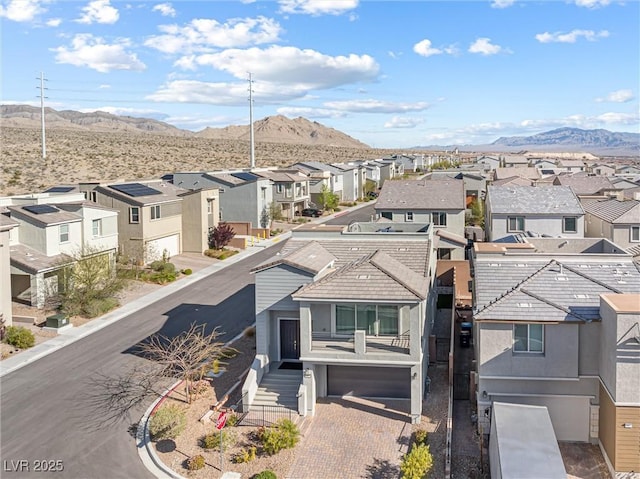 view of front of home with a mountain view, stucco siding, a residential view, and decorative driveway