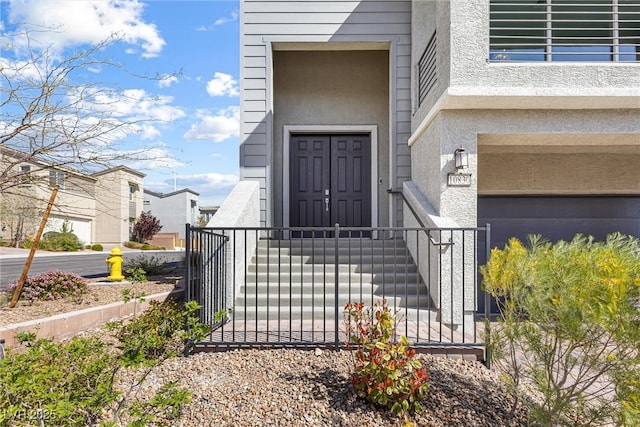 entrance to property featuring stucco siding and fence