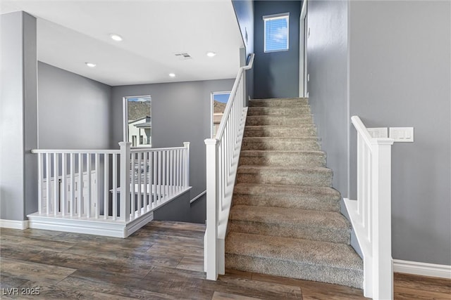 stairs featuring wood finished floors, baseboards, visible vents, and recessed lighting
