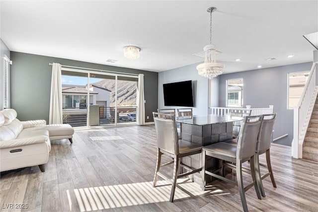 dining room with baseboards, an inviting chandelier, recessed lighting, stairway, and wood finished floors