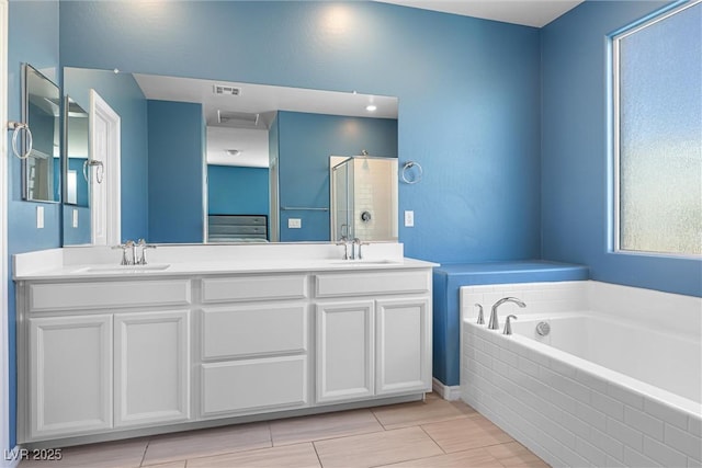 bathroom featuring a sink, visible vents, a bath, and a stall shower