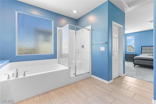 ensuite bathroom featuring a bath, a stall shower, ensuite bathroom, and baseboards