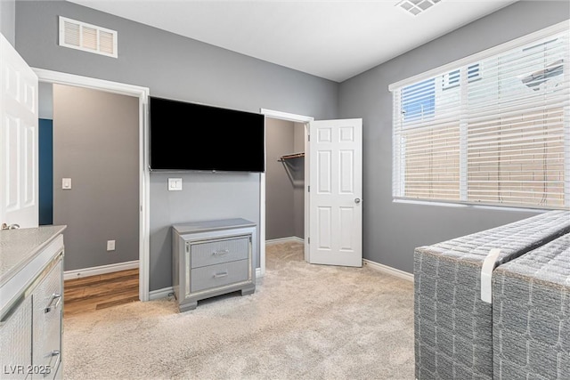 bedroom with light carpet, visible vents, and baseboards