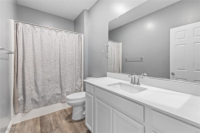 bathroom featuring toilet, shower / tub combo with curtain, vanity, and wood finished floors