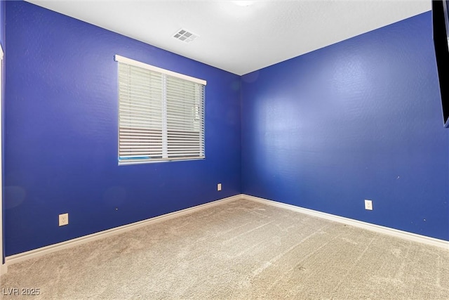 spare room with baseboards, carpet, and visible vents