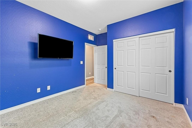 unfurnished bedroom featuring a closet, baseboards, and carpet