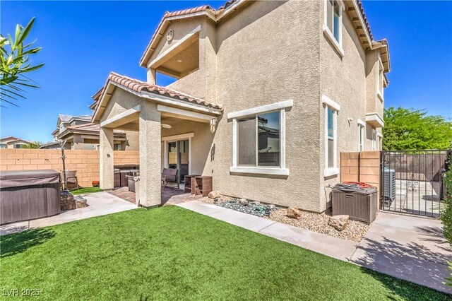 415 Carsin Wayne Ct, North Las Vegas, NV 89031 - back of house featuring a hot tub, stucco siding, a patio, a tile roof, and a gate