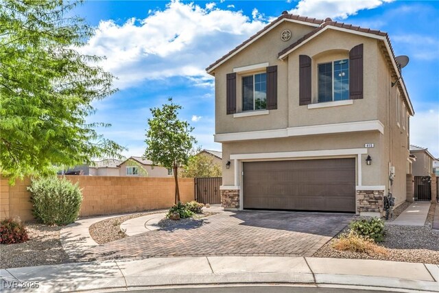 415 Carsin Wayne Ct, North Las Vegas, NV 89031 - view of front of property with stucco siding, decorative driveway, stone siding, a garage, and a gate