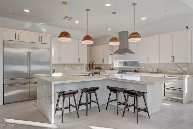 12199 Canyon Sunset St, Las Vegas, NV 89138 - kitchen with a kitchen breakfast bar, built in fridge, visible vents, wall chimney exhaust hood, and a sink
