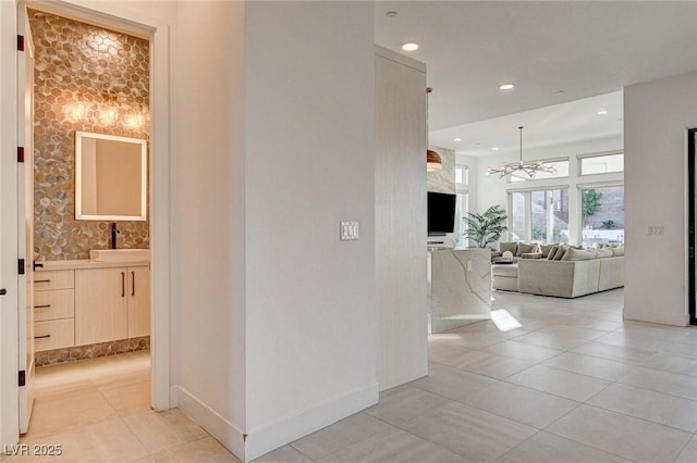 12199 Canyon Sunset St, Las Vegas, NV 89138 - hall featuring a notable chandelier, baseboards, recessed lighting, light tile patterned floors, and a sink