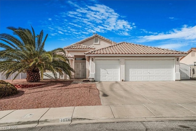 1066 Vanlier Ln, Henderson, NV 89015 - view of front of house featuring a garage, concrete driveway, stucco siding, and a tiled roof