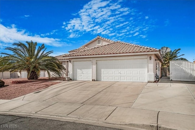 1066 Vanlier Ln, Henderson, NV 89015 - view of front of home with concrete driveway, an attached garage, stucco siding, a gate, and a tiled roof