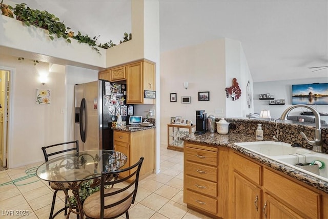 1066 Vanlier Ln, Henderson, NV 89015 - kitchen with a sink, light tile patterned floors, stainless steel fridge with ice dispenser, and dark stone counters