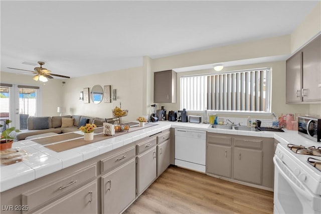 5530 Berchmans Ave, Las Vegas, NV 89122 - kitchen with white appliances, light wood-type flooring, a peninsula, open floor plan, and ceiling fan