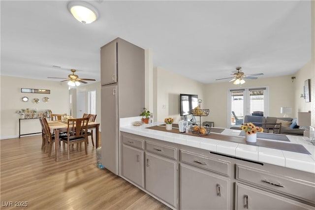 5530 Berchmans Ave, Las Vegas, NV 89122 - kitchen featuring ceiling fan, open floor plan, tile counters, and light wood finished floors