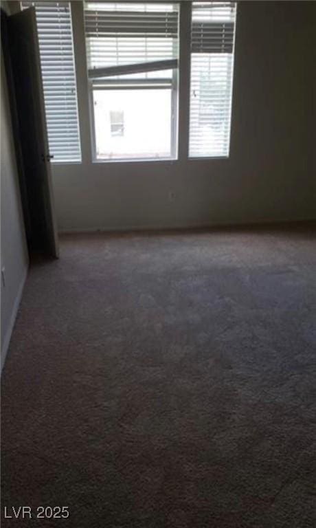 empty room featuring dark colored carpet
