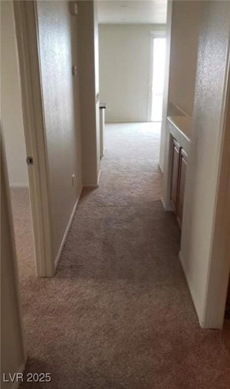 hall with light colored carpet