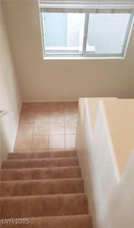 stairway with tile patterned floors