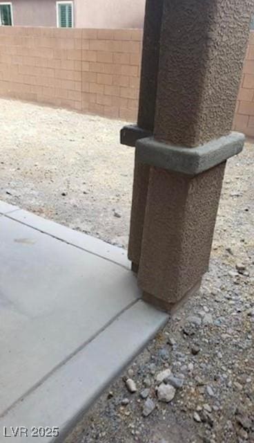 details featuring fence and stucco siding