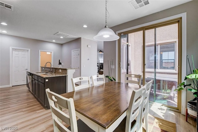 dining room with light wood-style floors, recessed lighting, and baseboards