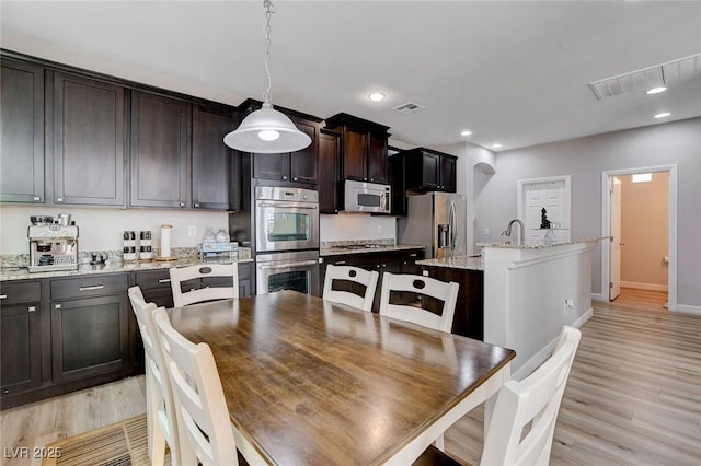 dining space featuring light wood-style flooring, baseboards, and recessed lighting