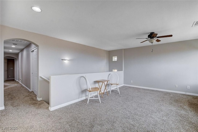 living area featuring a ceiling fan, arched walkways, carpet flooring, baseboards, and recessed lighting