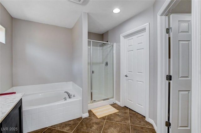bathroom featuring a stall shower, a bath, tile patterned flooring, and vanity