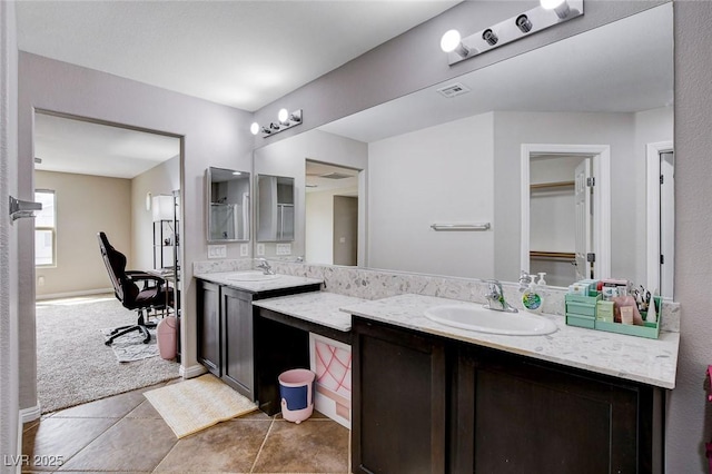 bathroom featuring double vanity, tile patterned floors, and a walk in closet