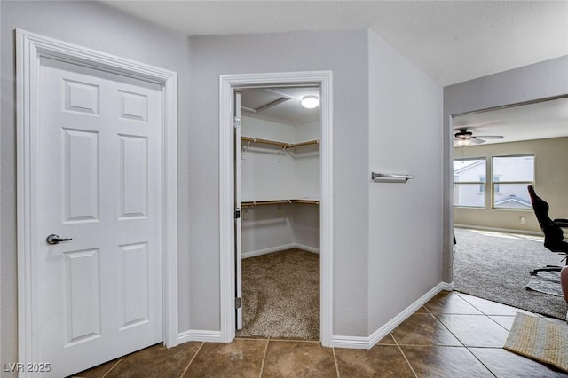 interior space with carpet floors, tile patterned flooring, and baseboards