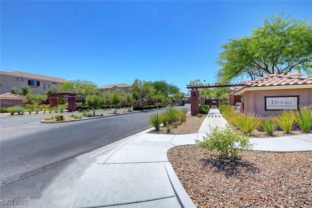 view of asphalt road featuring sidewalks and curbs