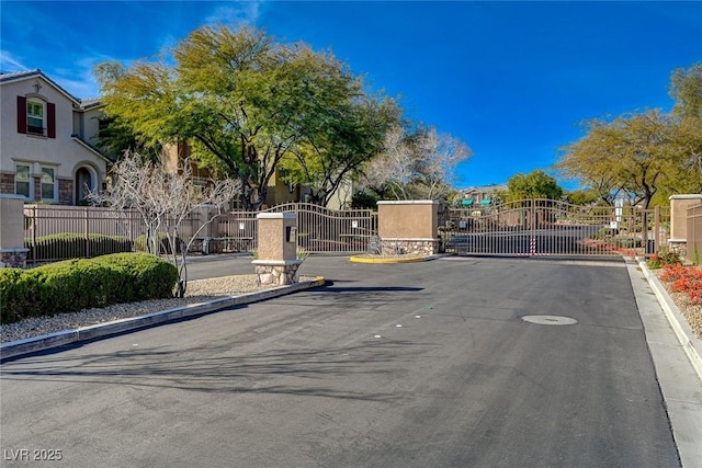 11036 Mount Hunter St, Las Vegas, NV 89179 - view of asphalt street with curbs, a gated entry, and a gate