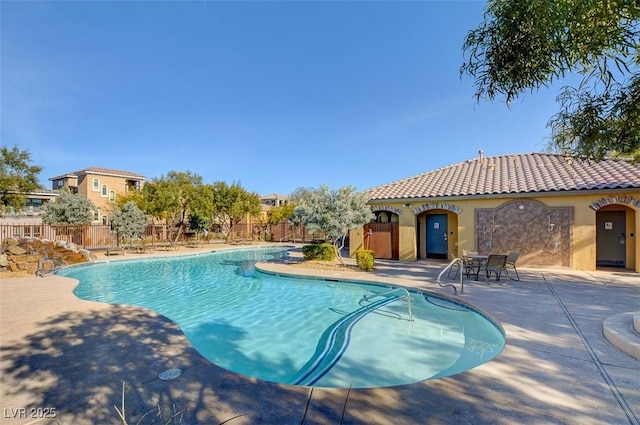 community pool featuring fence and a patio area