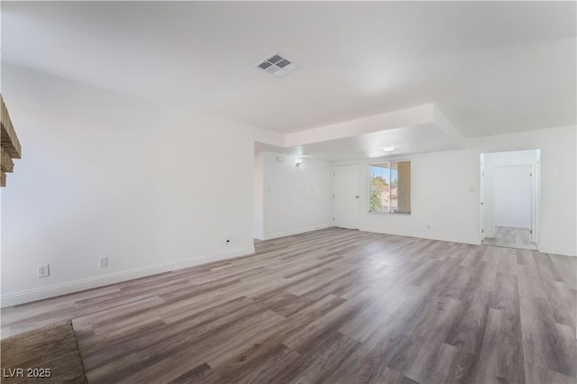 unfurnished living room with visible vents, baseboards, and wood finished floors