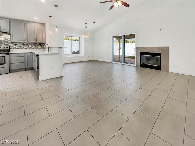 kitchen featuring a sink, open floor plan, light countertops, gray cabinetry, and electric range