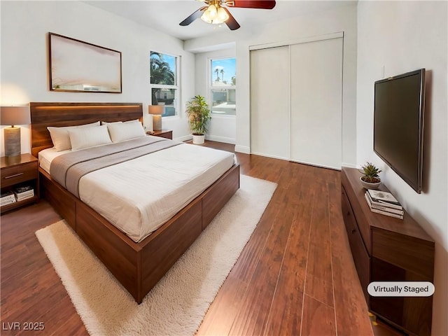 bedroom with a closet, dark wood-style flooring, and a ceiling fan